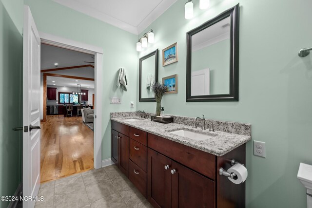 bathroom featuring wood-type flooring, ceiling fan, crown molding, and vanity