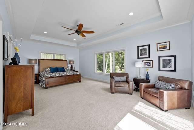 carpeted bedroom with a raised ceiling, ceiling fan, and ornamental molding