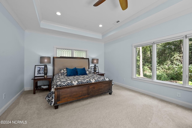 carpeted bedroom featuring multiple windows, ceiling fan, a raised ceiling, and ornamental molding