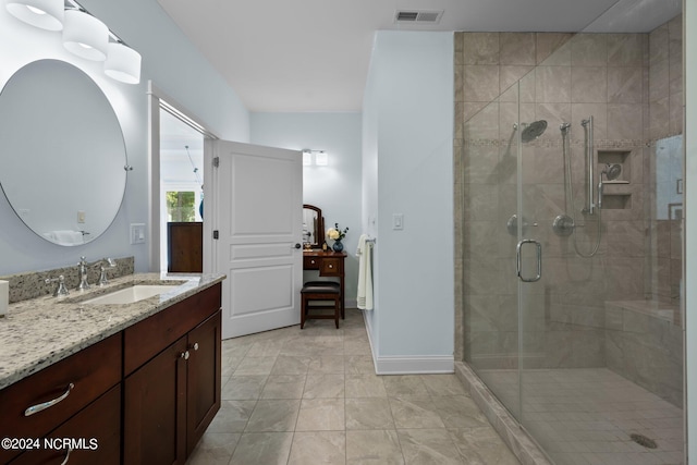 bathroom featuring vanity, walk in shower, and tile patterned flooring