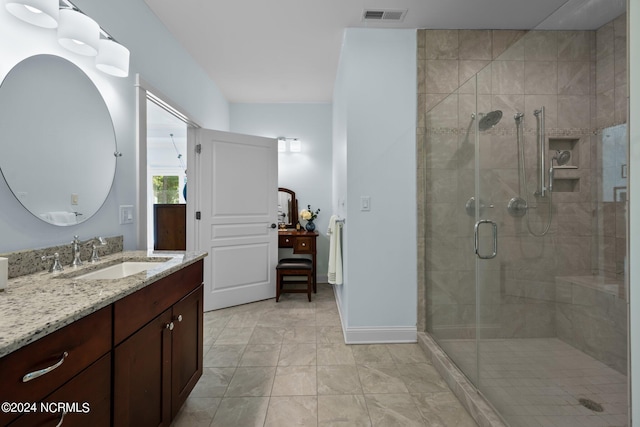 bathroom with a stall shower, visible vents, vanity, and baseboards