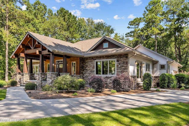 craftsman inspired home featuring a porch and stone siding