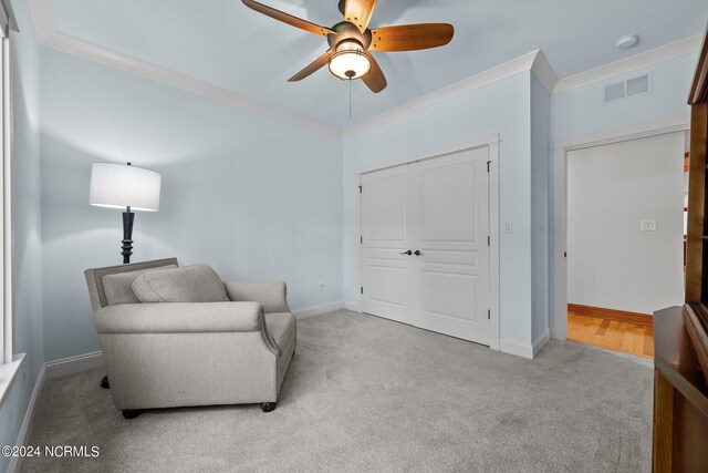 sitting room featuring ornamental molding, ceiling fan, and carpet