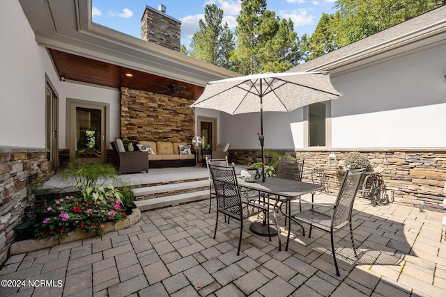 view of patio featuring outdoor dining space, ceiling fan, and an outdoor hangout area