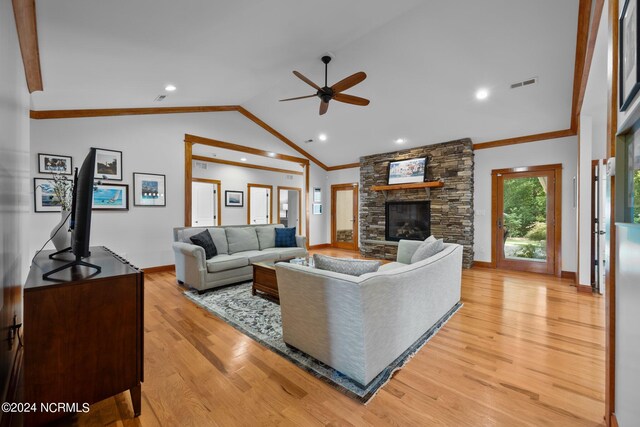 living room featuring a fireplace, ornamental molding, light hardwood / wood-style flooring, ceiling fan, and vaulted ceiling