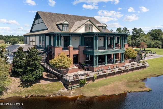 rear view of property with a water view and a balcony