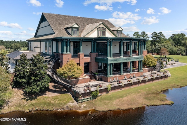 rear view of house featuring stairs, a patio, a water view, and a balcony