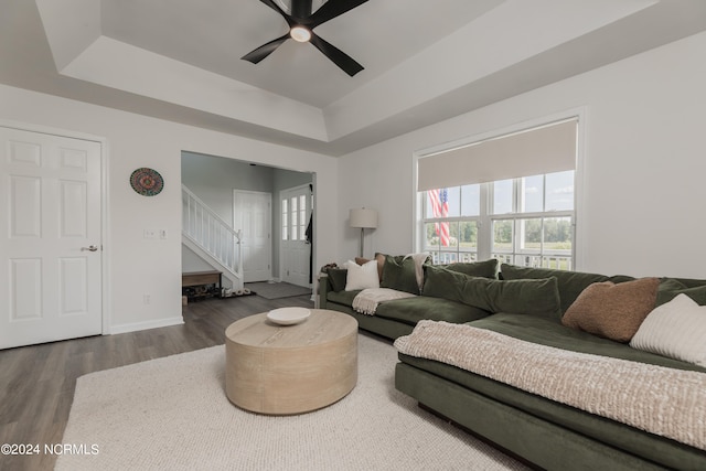 living room featuring ceiling fan, a raised ceiling, and hardwood / wood-style floors