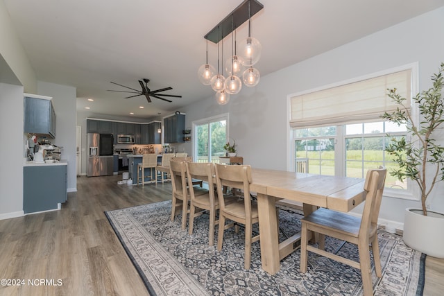 dining room featuring ceiling fan with notable chandelier and dark hardwood / wood-style floors