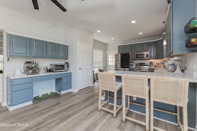 kitchen with recessed lighting, a toaster, light countertops, appliances with stainless steel finishes, and light wood-type flooring