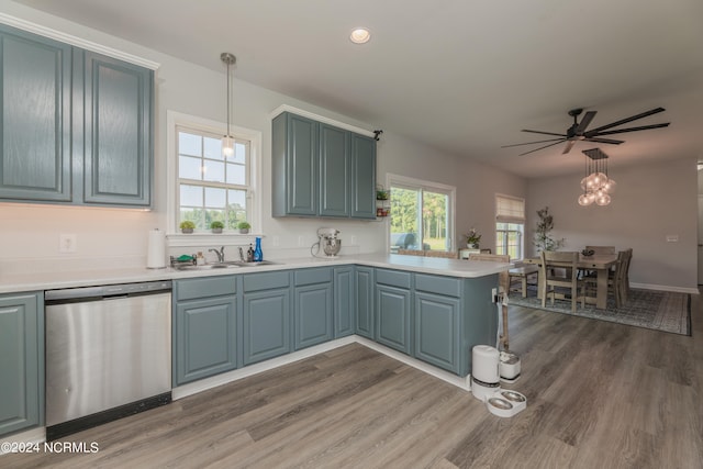 kitchen with dark wood-type flooring, sink, kitchen peninsula, hanging light fixtures, and stainless steel dishwasher