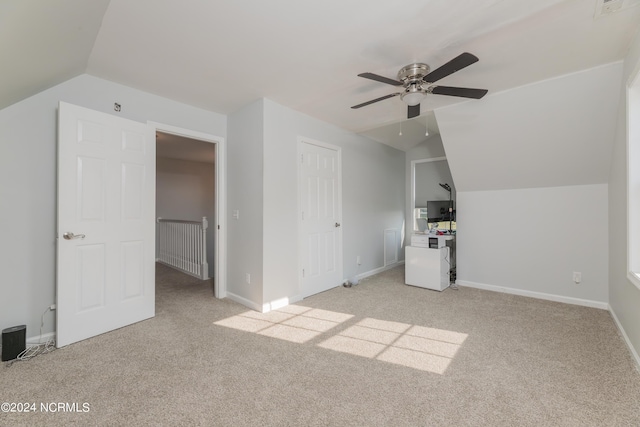 additional living space with light colored carpet, vaulted ceiling, and baseboards