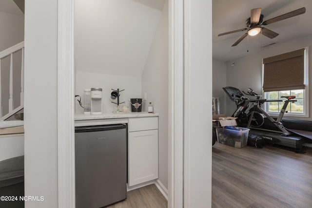 bar with white cabinets, light hardwood / wood-style floors, ceiling fan, and stainless steel refrigerator