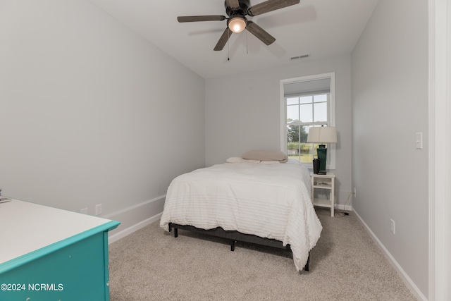 bedroom featuring baseboards, ceiling fan, visible vents, and light colored carpet