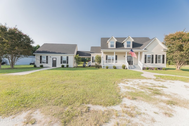 cape cod-style house featuring a front lawn and covered porch