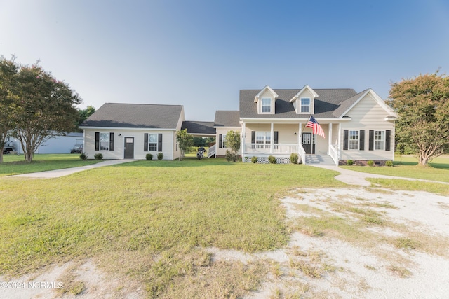 cape cod-style house with covered porch and a front yard