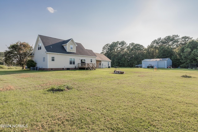 view of yard with an outdoor fire pit, central air condition unit, and a wooden deck