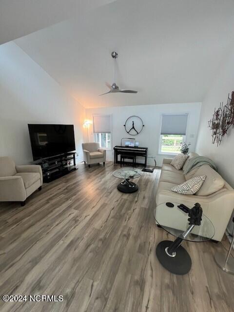 living room with lofted ceiling, wood-type flooring, and ceiling fan