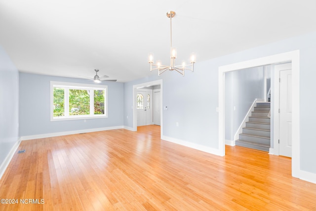 31 Augusta Dr, Oak Island, NC 28465 - unfurnished room featuring light wood-style flooring, baseboards, visible vents, ceiling fan with notable chandelier, and stairs