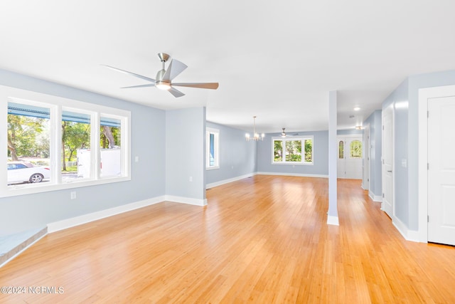 31 Augusta Dr, Oak Island, NC 28465 - unfurnished living room featuring baseboards, light wood finished floors, and ceiling fan with notable chandelier