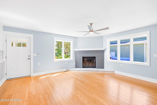 31 Augusta Dr, Oak Island, NC 28465 - unfurnished living room featuring light wood finished floors, a brick fireplace, baseboards, and a ceiling fan
