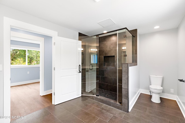 bathroom featuring toilet and a shower with door