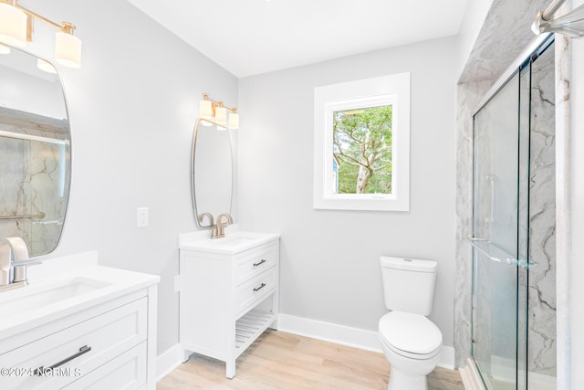 bathroom with toilet, an enclosed shower, hardwood / wood-style floors, and vanity