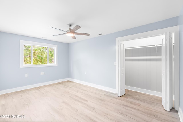 unfurnished bedroom featuring light wood-type flooring, ceiling fan, and a closet