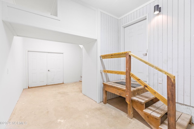 stairway with wooden walls and concrete flooring