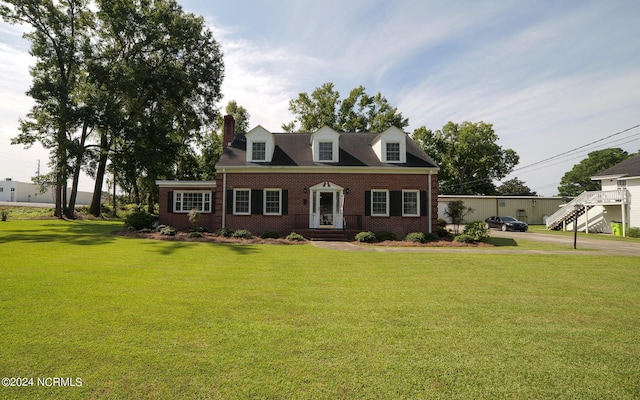 cape cod-style house with brick siding and a front lawn