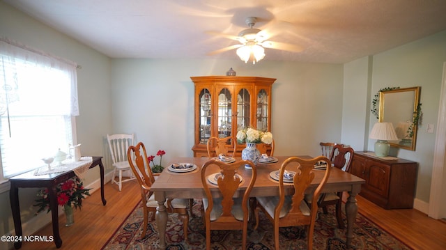 dining area featuring ceiling fan, light wood-style flooring, and baseboards