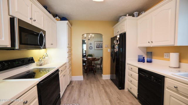 kitchen with light wood-type flooring, arched walkways, white cabinets, and black appliances