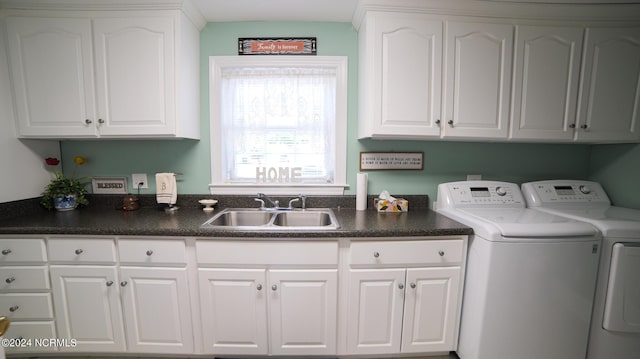 laundry area featuring cabinet space, separate washer and dryer, and a sink