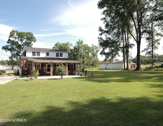 view of front facade with brick siding and a front yard