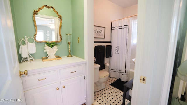 full bath with tile walls, toilet, shower / bath combo with shower curtain, wainscoting, and vanity