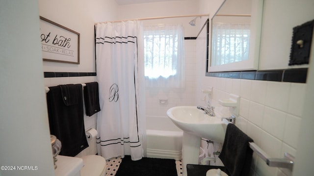 full bathroom with toilet, shower / bath combo, and tile walls