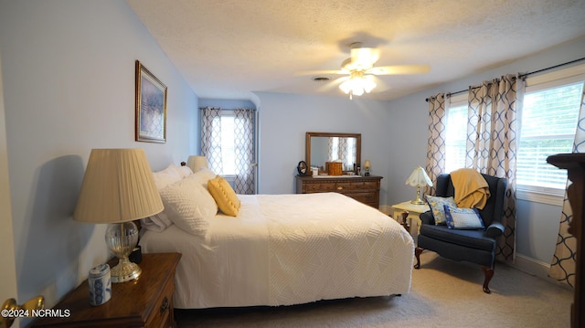 bedroom with carpet floors, baseboards, a ceiling fan, and a textured ceiling