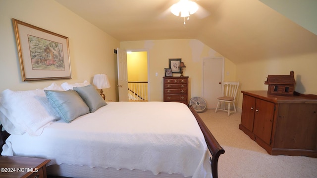 bedroom with vaulted ceiling and light colored carpet