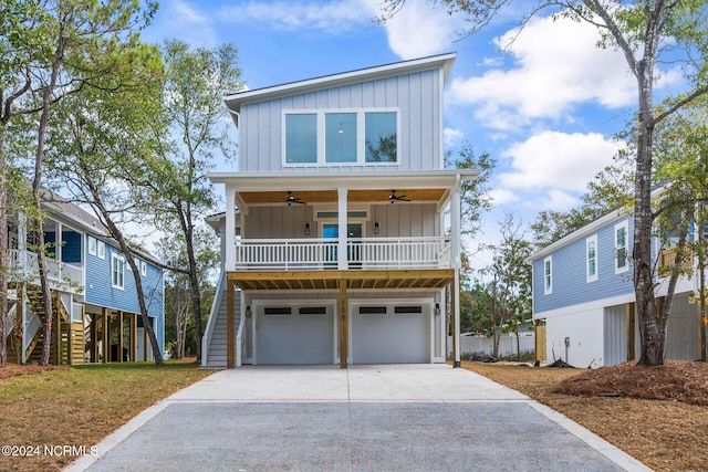 coastal home featuring covered porch, a garage, and ceiling fan