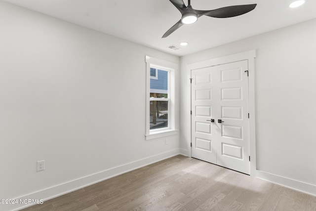 unfurnished bedroom with light hardwood / wood-style flooring, a closet, and ceiling fan