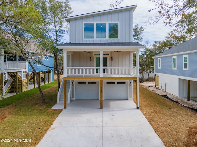 view of front of property featuring a front yard, a garage, and a porch