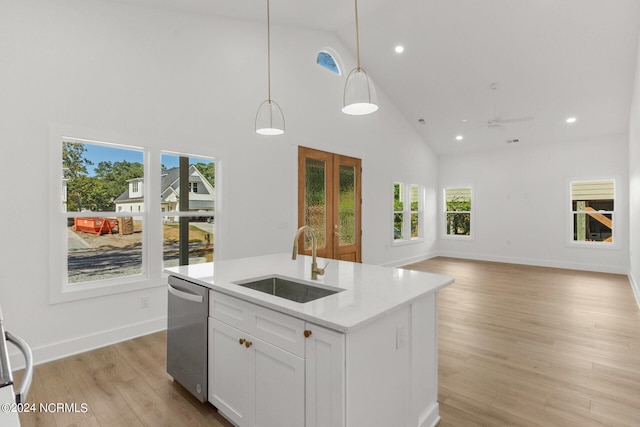 kitchen featuring sink, hanging light fixtures, white cabinetry, stainless steel dishwasher, and high vaulted ceiling