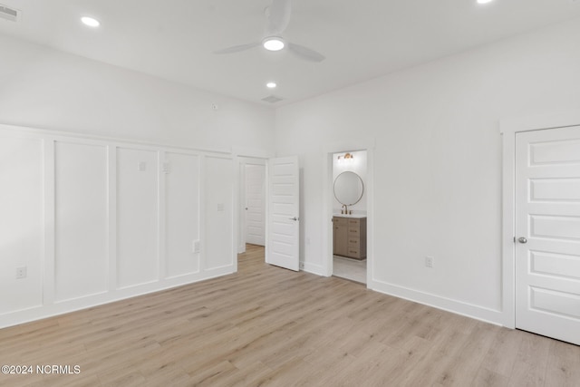 unfurnished bedroom with sink, ceiling fan, light wood-type flooring, and ensuite bath