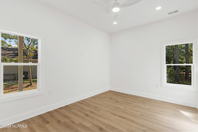 unfurnished room featuring a healthy amount of sunlight, light wood-type flooring, and ceiling fan