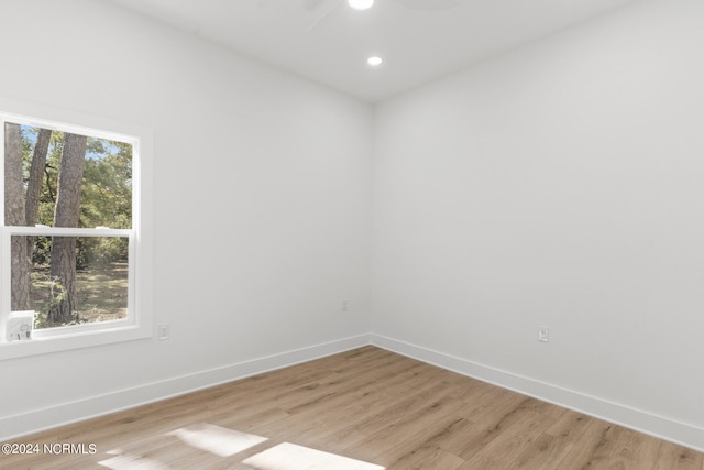 spare room with light hardwood / wood-style floors, a healthy amount of sunlight, and ceiling fan