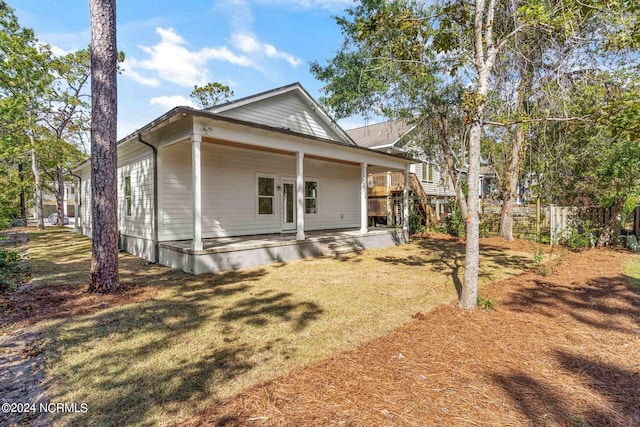 rear view of house featuring a yard