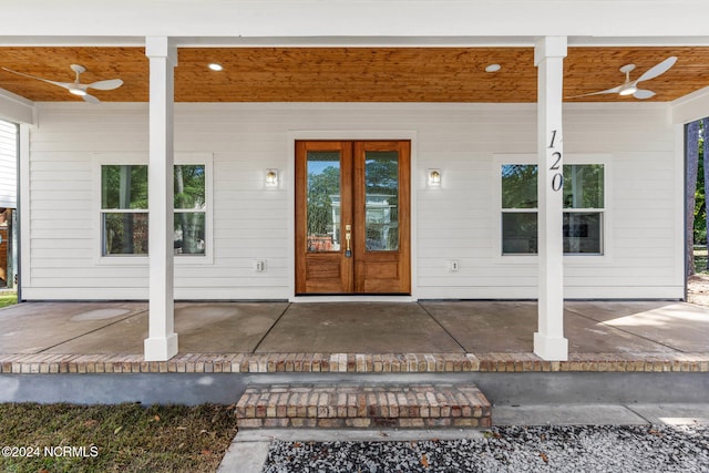 view of exterior entry with french doors, ceiling fan, and a patio area