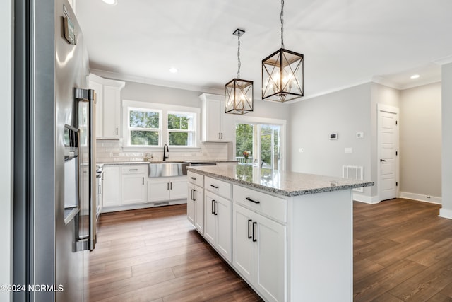 kitchen featuring white cabinets, decorative light fixtures, dark wood-type flooring, and a center island