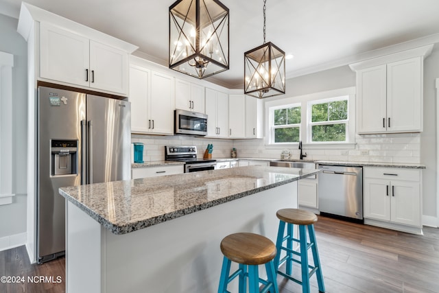 kitchen featuring dark hardwood / wood-style floors, a notable chandelier, white cabinetry, hanging light fixtures, and stainless steel appliances