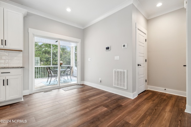 unfurnished dining area with ornamental molding and dark hardwood / wood-style flooring